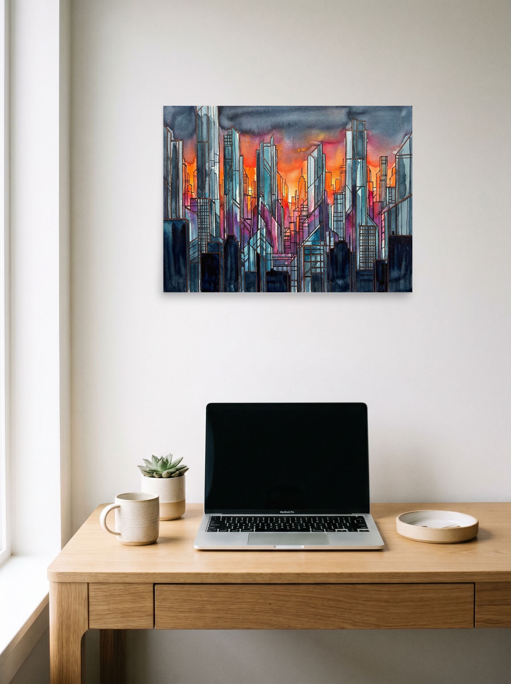 A 24x18 inch unframed paper Cubism,Abstract expressionism print of 'City Skyline' hanging above a worktable with a laptop.