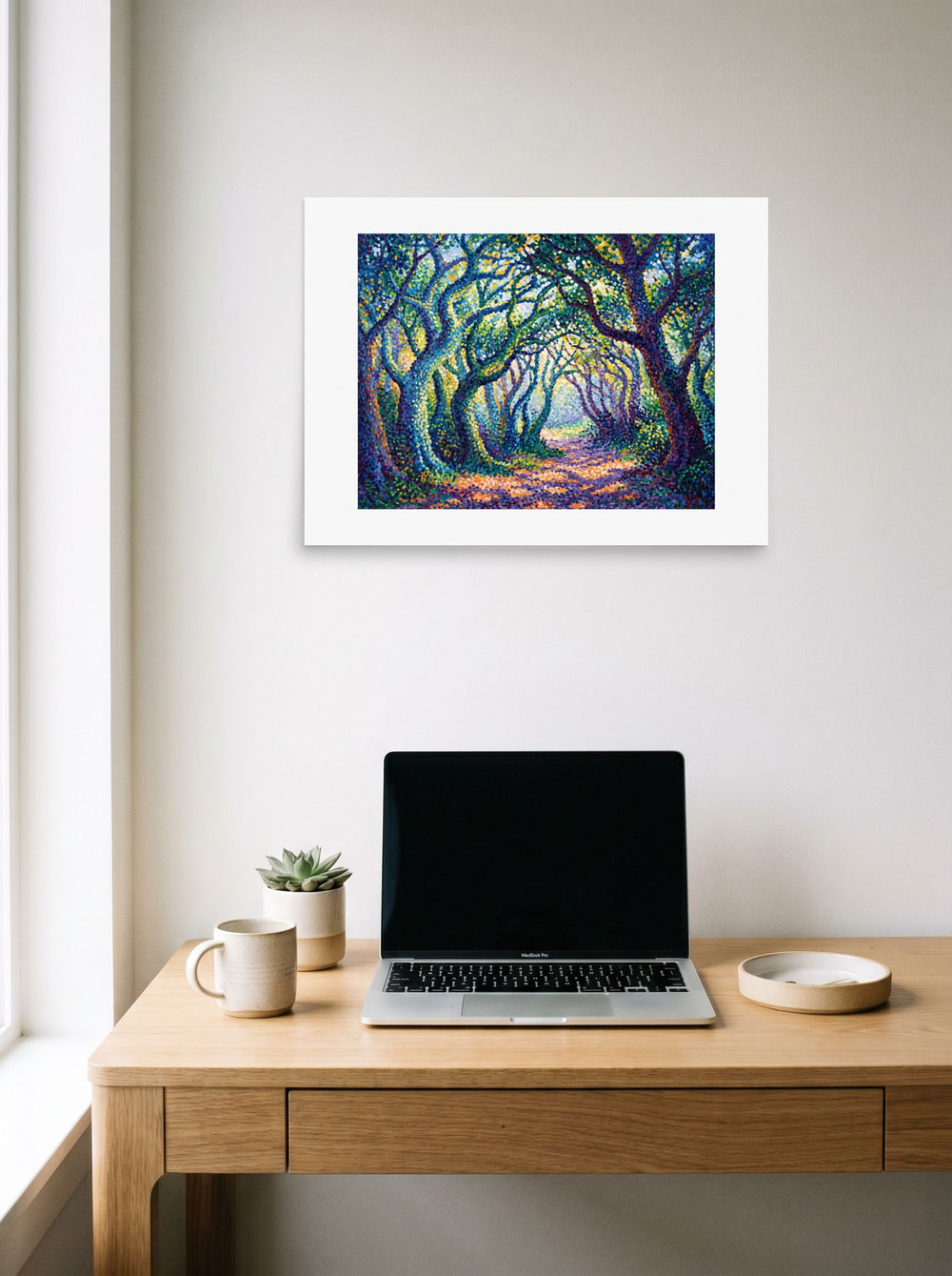 The Pointillism print 'The Enchanted Forest Path', 24x18 inch unframed paper, hanging above a worktable with a laptop.