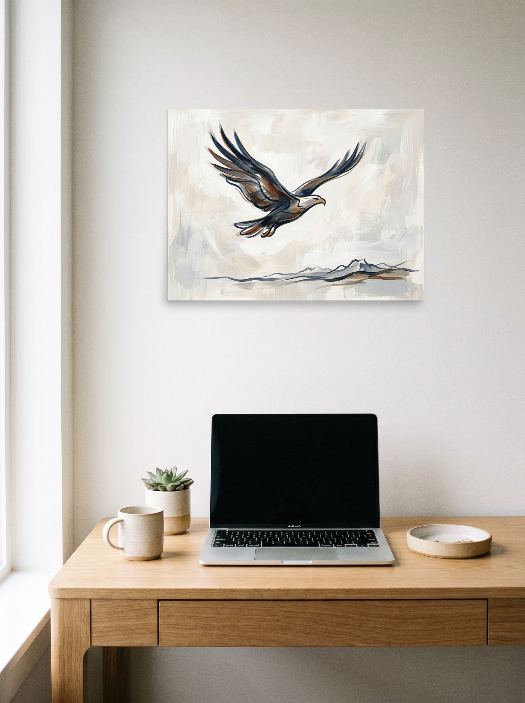 A 24x18 inch unframed paper Minimalism,Lyrical abstraction print of 'Soaring Eagle' hanging above a worktable with a laptop.
