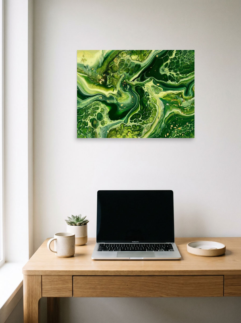 A 24x18 inch unframed paper Abstract art print of 'Emerald Flow' hanging above a worktable with a laptop.
