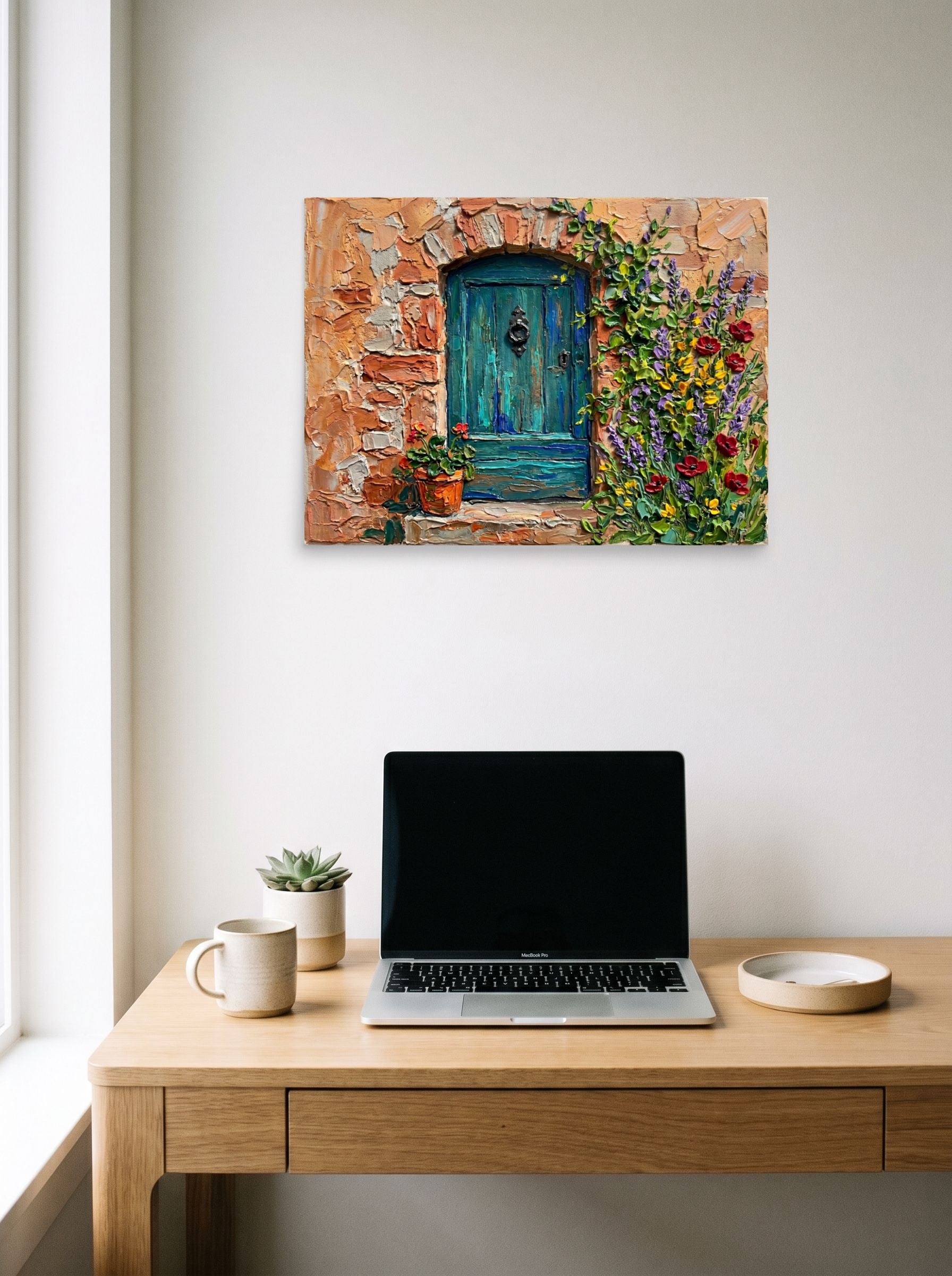 A 24x18 inch unframed paper Impressionism print of 'The Hidden Courtyard Door' hanging above a worktable with a laptop.