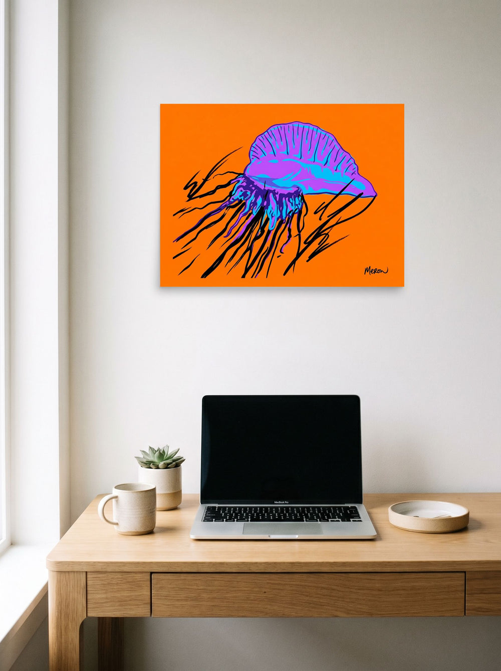 A 24x18 inch unframed paper Pop art print of 'Neon Man o' War' hanging above a worktable with a laptop.