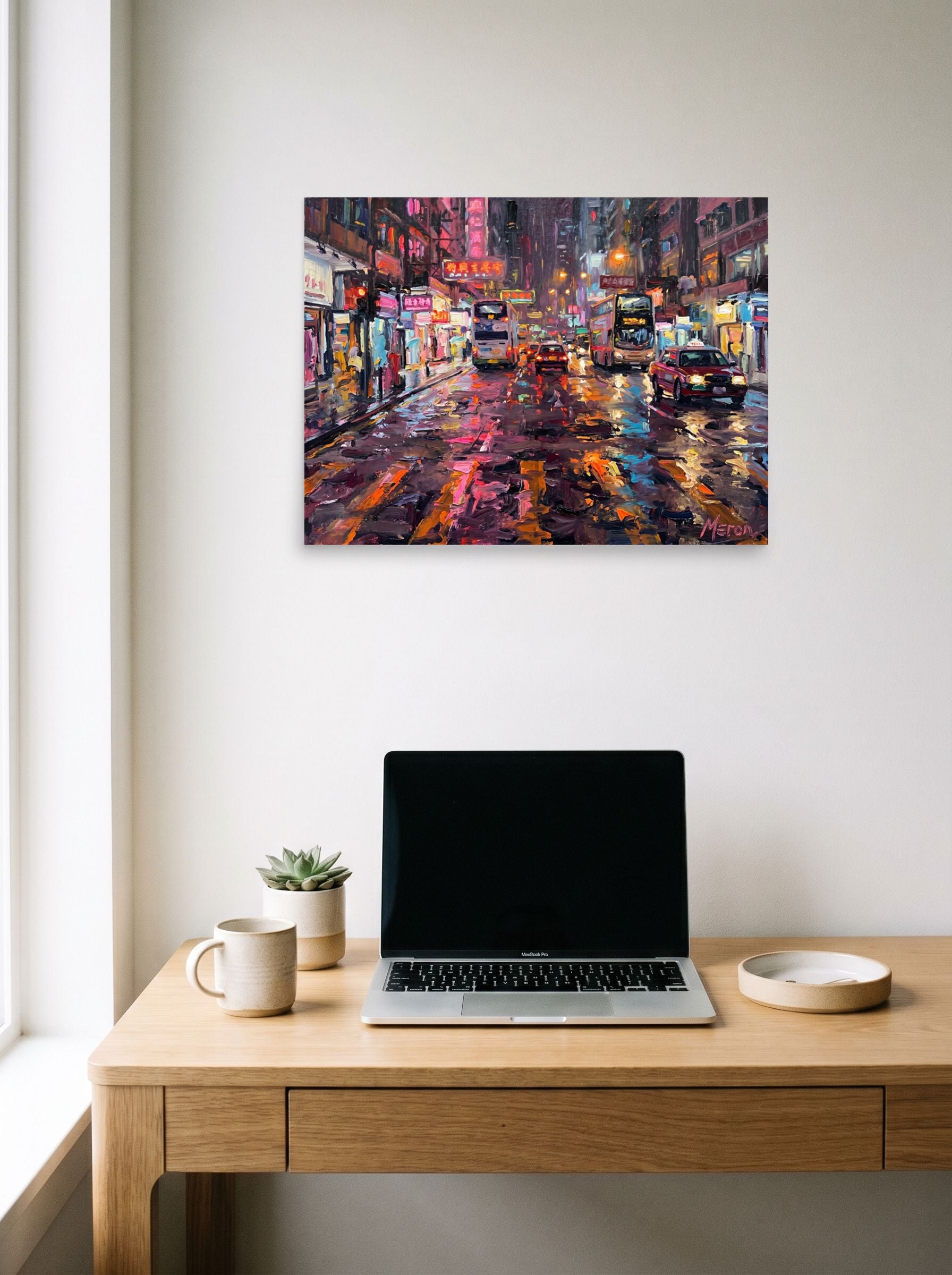 A 24x18 inch unframed paper Impressionism print of 'Neon Night Reflections' hanging above a worktable with a laptop.