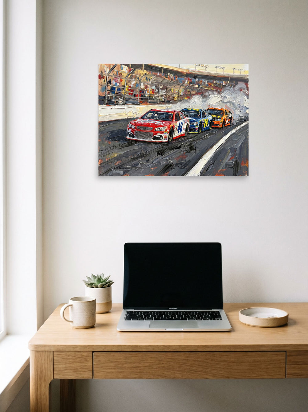 A 24x18 inch unframed paper Expressionism print of 'Thunder on the Track' hanging above a worktable with a laptop.