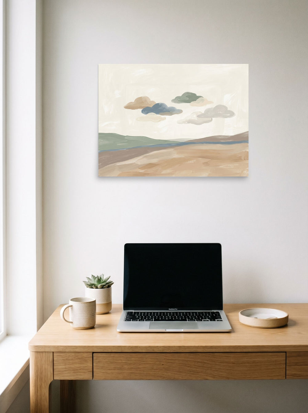 A 24x18 inch unframed paper Minimalism print of 'Whispering Horizons' hanging above a worktable with a laptop.