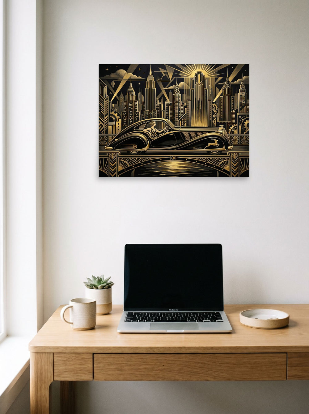 A 24x18 inch unframed paper Art Deco print of 'The Golden Drive' hanging above a worktable with a laptop.