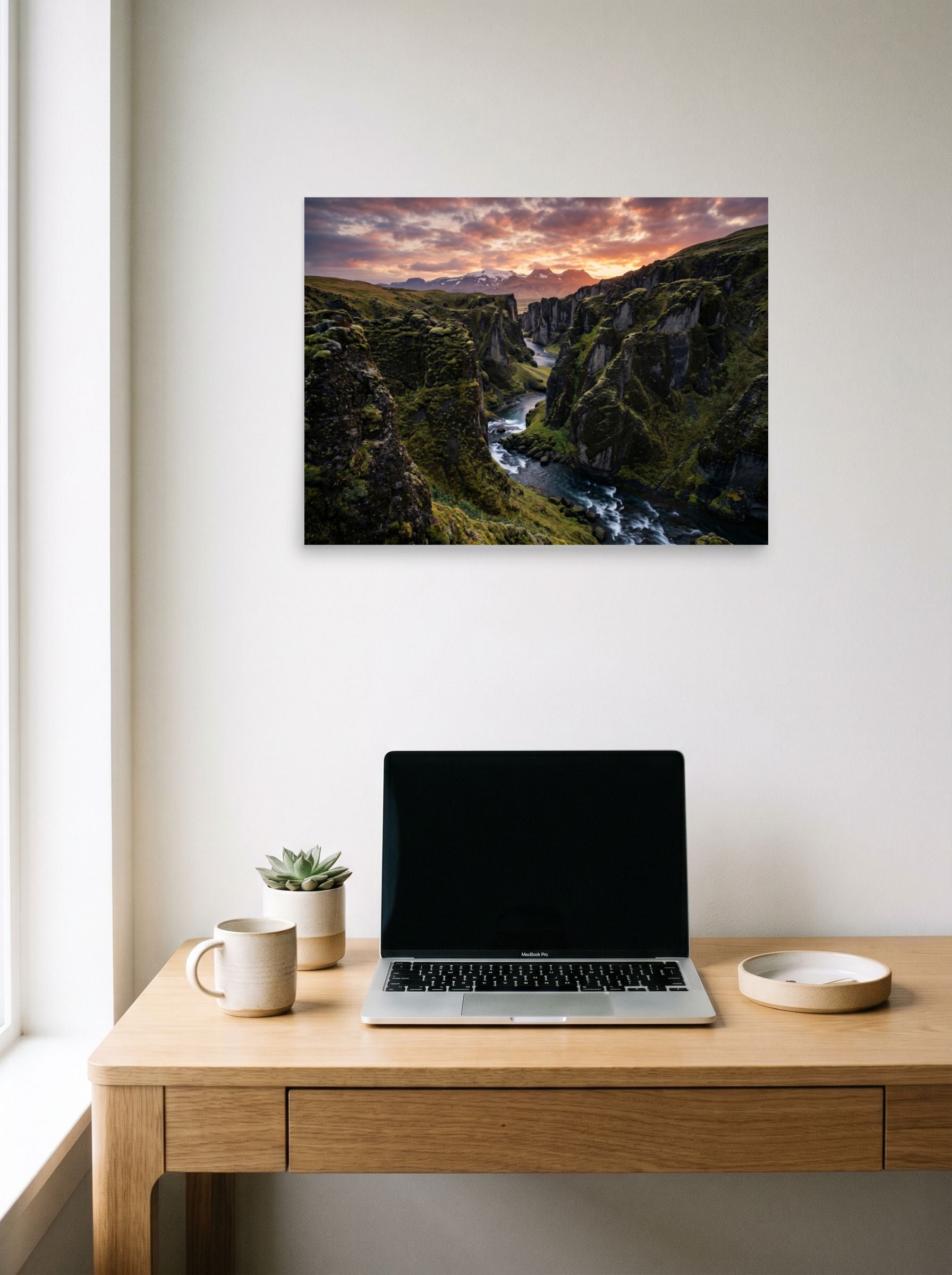 A 24x18 inch unframed paper Art photography print of 'Canyon of the Dawn' hanging above a worktable with a laptop.
