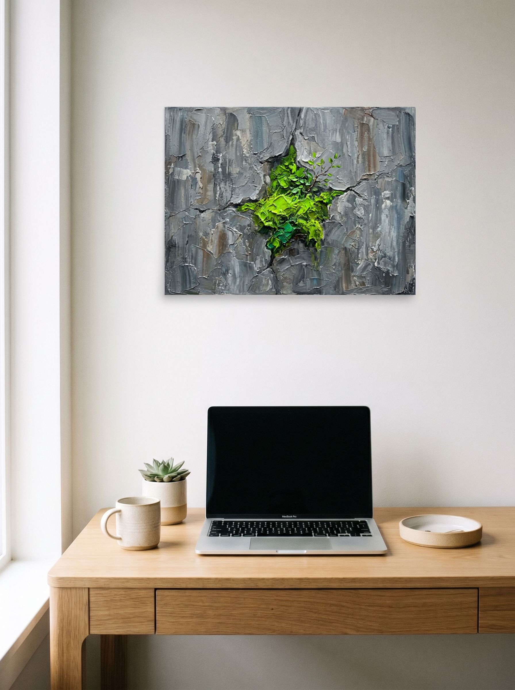 A 24x18 inch unframed paper Realism print of 'Life Finds a Way' hanging above a worktable with a laptop.