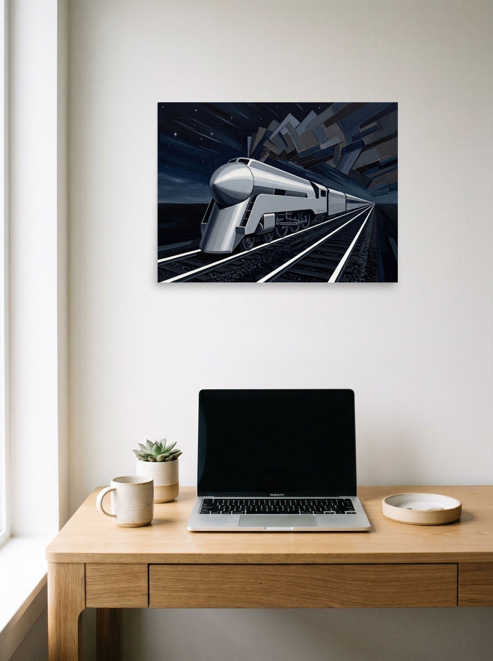 A 24x18 inch unframed paper Art Deco print of 'Midnight Express' hanging above a worktable with a laptop.