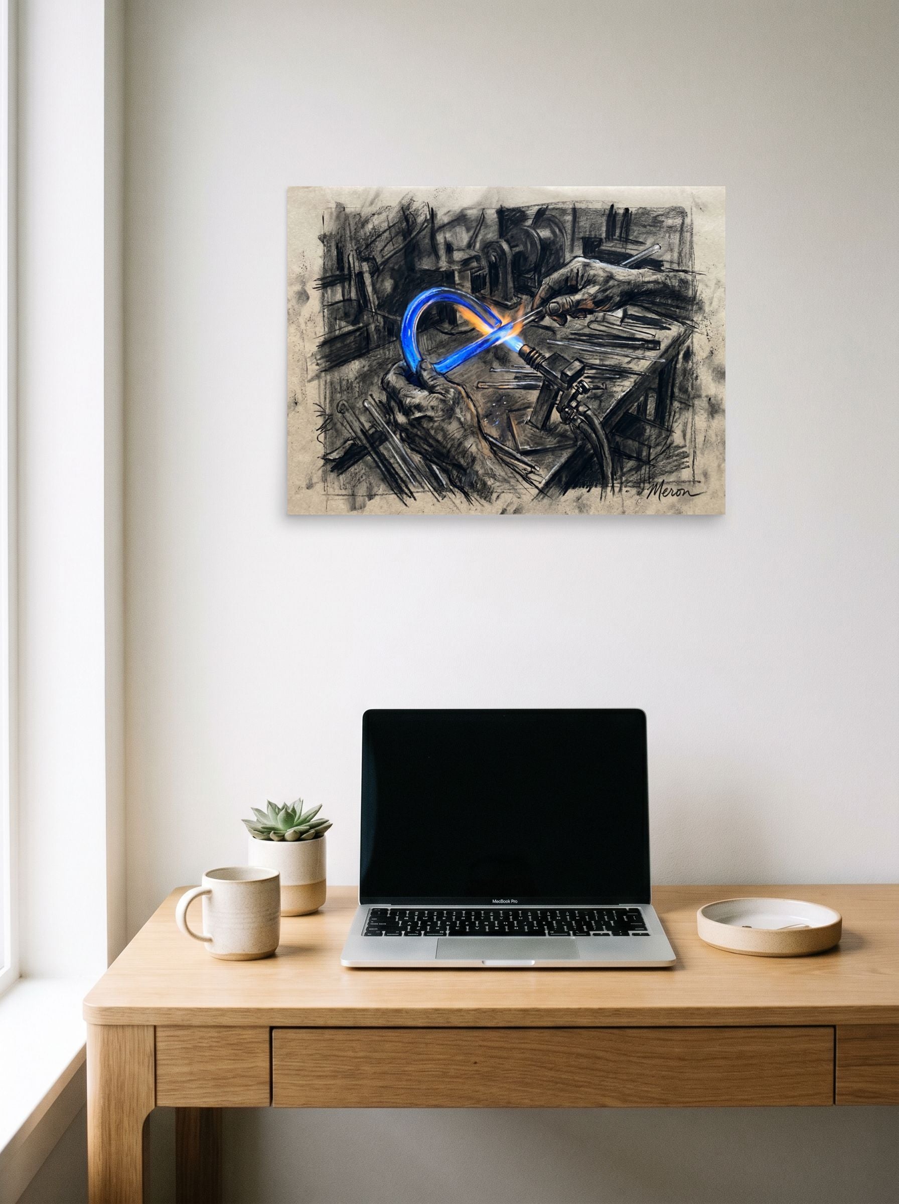 A 24x18 inch unframed paper Realism print of 'The Neon Maker' hanging above a worktable with a laptop.