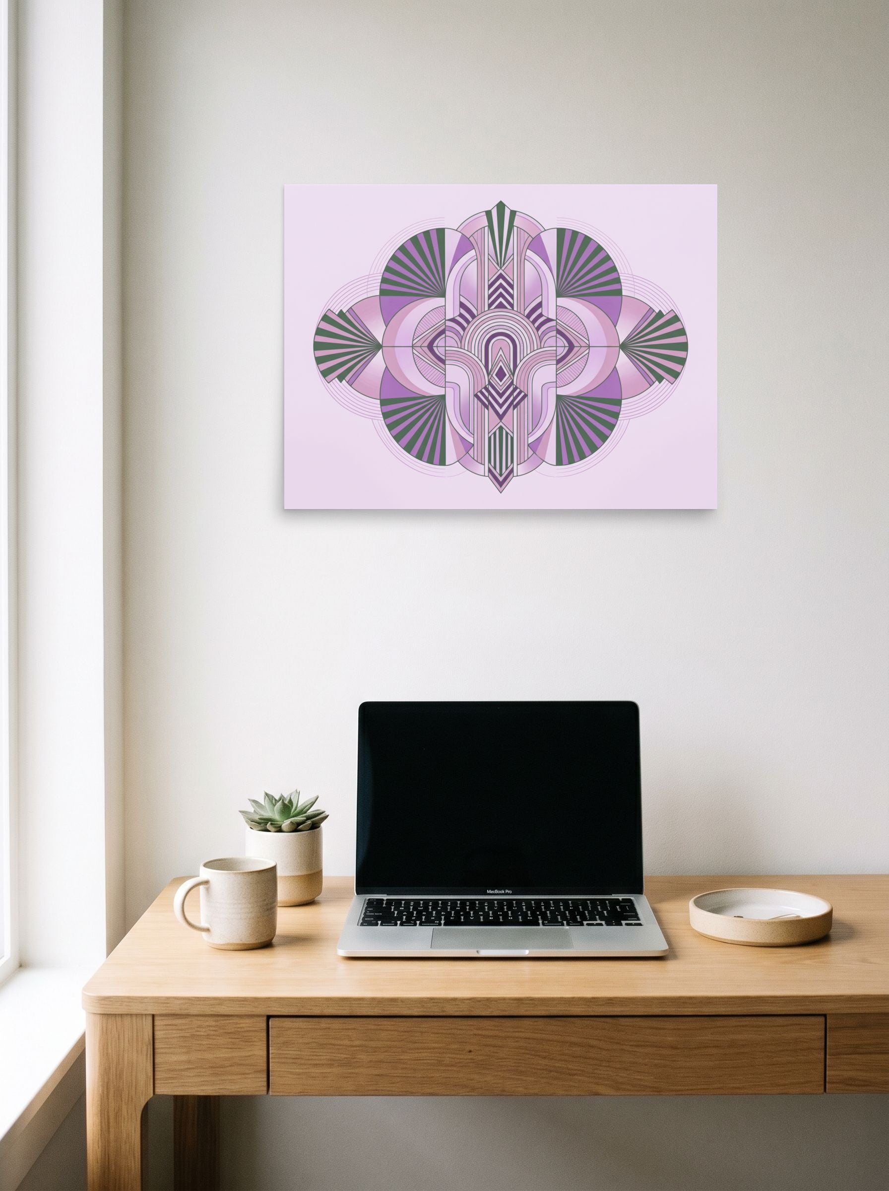 A 24x18 inch unframed paper Art Deco print of 'Lavender Deco Symmetry' hanging above a worktable with a laptop.