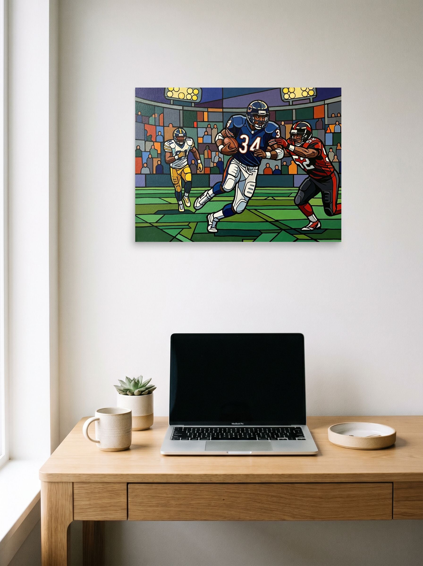 A 24x18 inch unframed paper Cloisonnism print of 'The Breakaway Run' hanging above a worktable with a laptop.