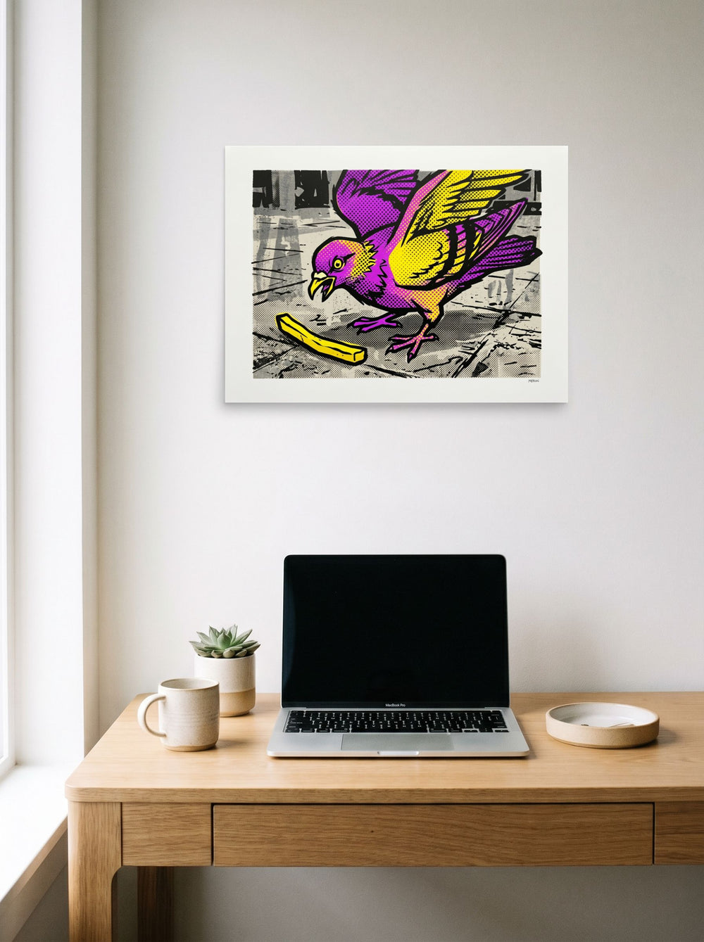 A 24x18 inch unframed paper Pop art print of 'The Urban Forager' hanging above a worktable with a laptop.