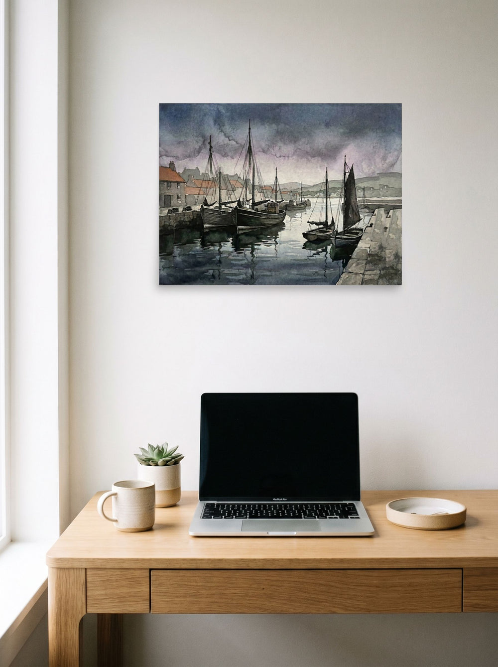 A 24x18 inch unframed paper Realism print of 'Harbor at Dusk' hanging above a worktable with a laptop.