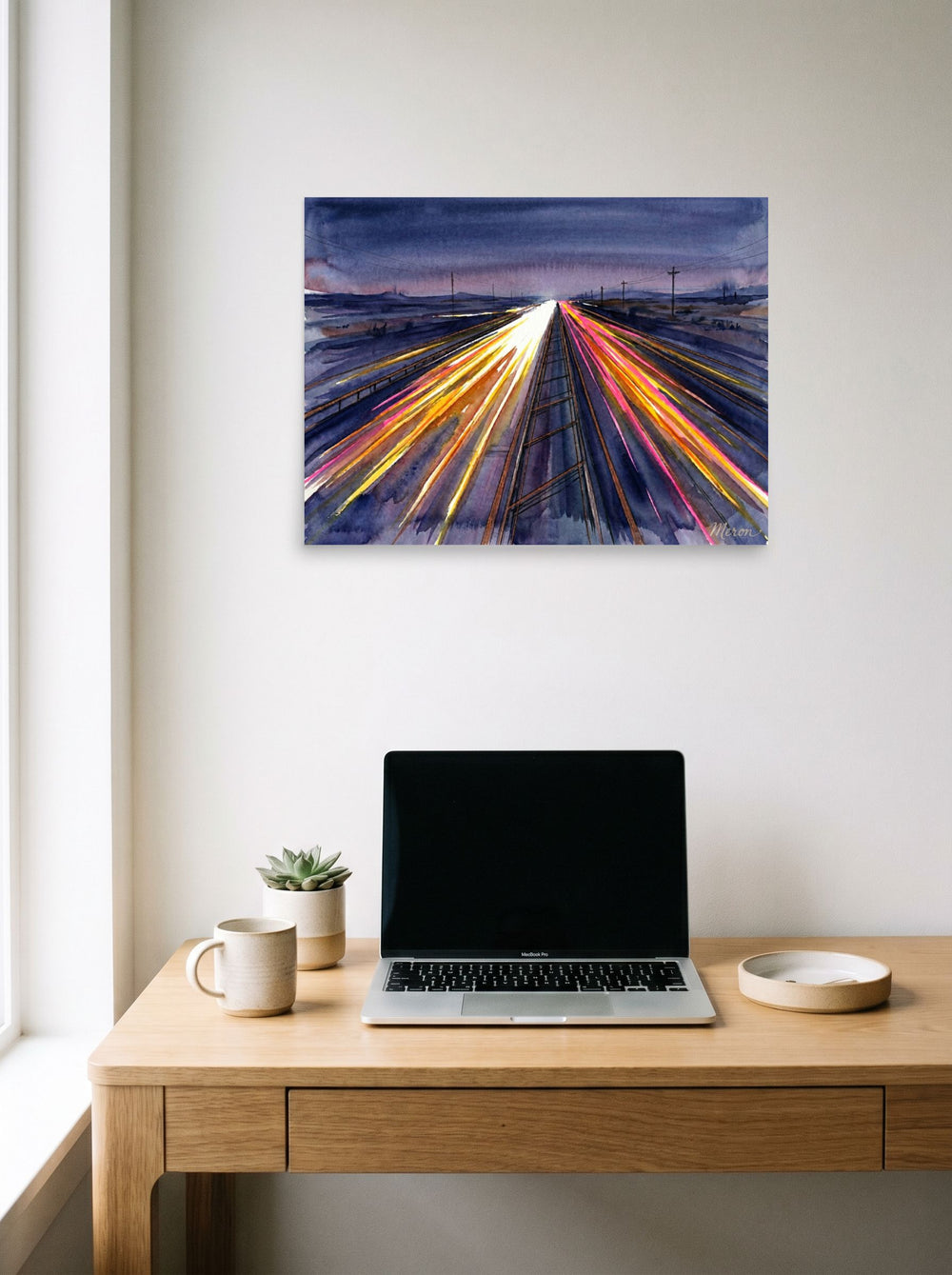 A 24x18 inch unframed paper Futurism print of 'The American Interstate' hanging above a worktable with a laptop.