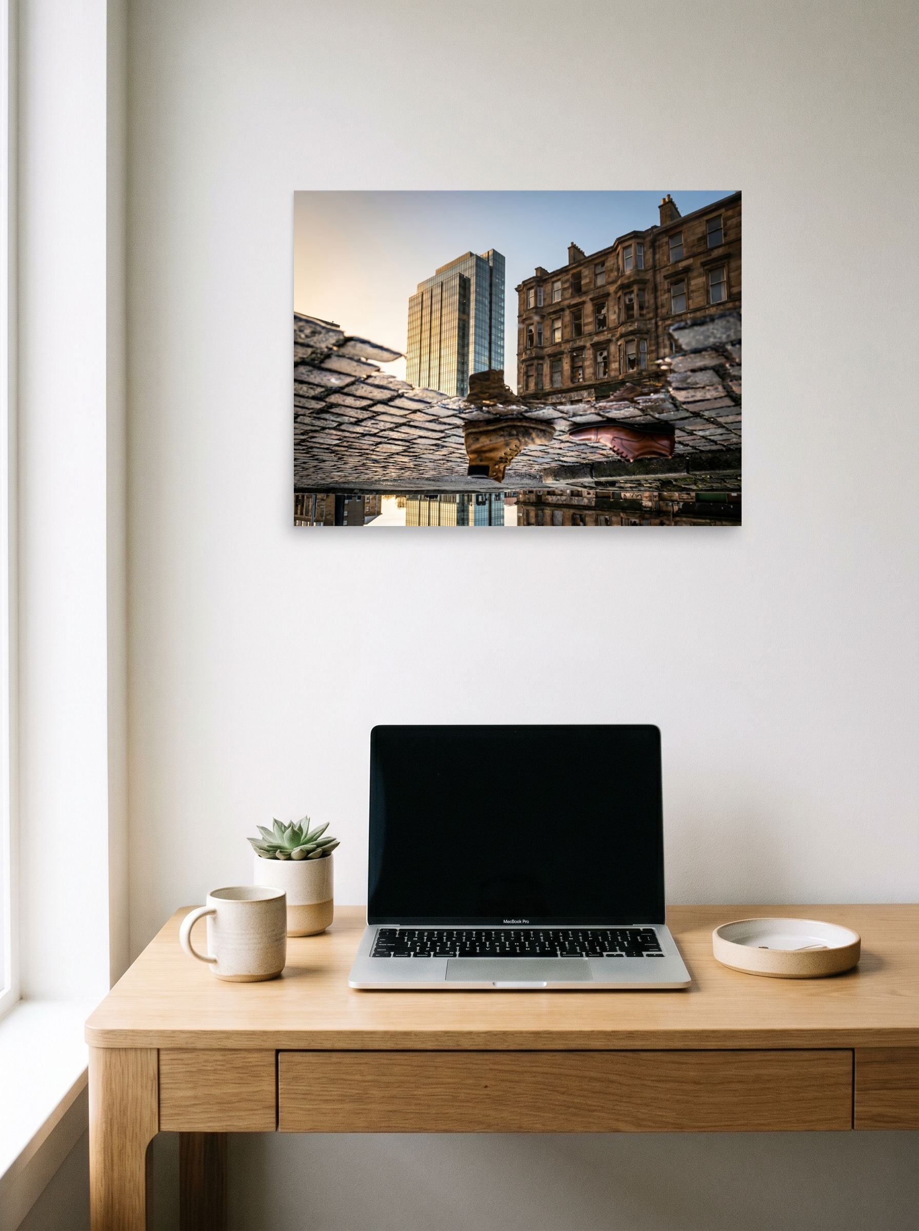 A 24x18 inch unframed paper Art photography print of 'Steps Through Time' hanging above a worktable with a laptop.