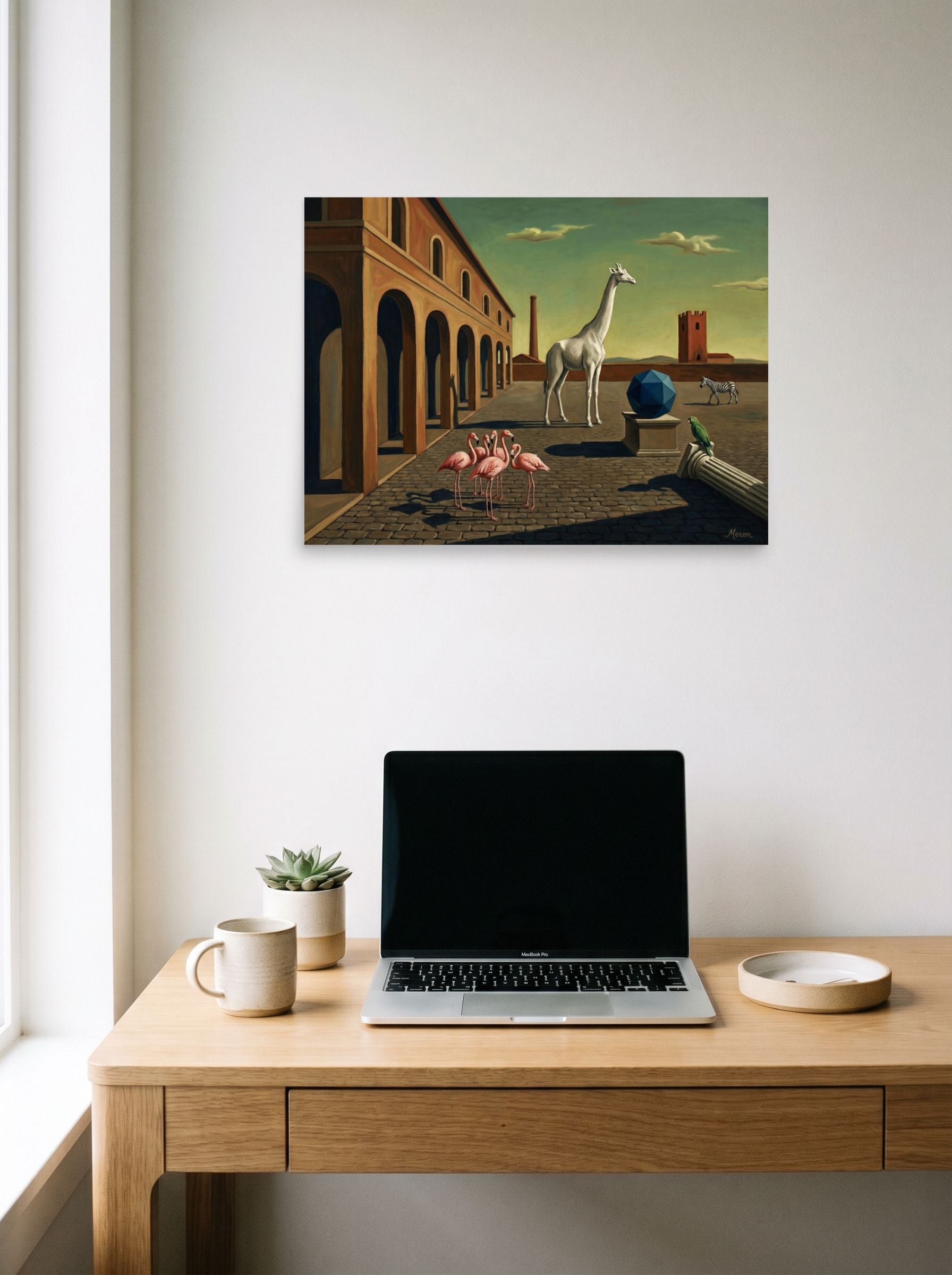 A 24x18 inch unframed paper Surrealism print of 'The Giraffe's Geometry' hanging above a worktable with a laptop.