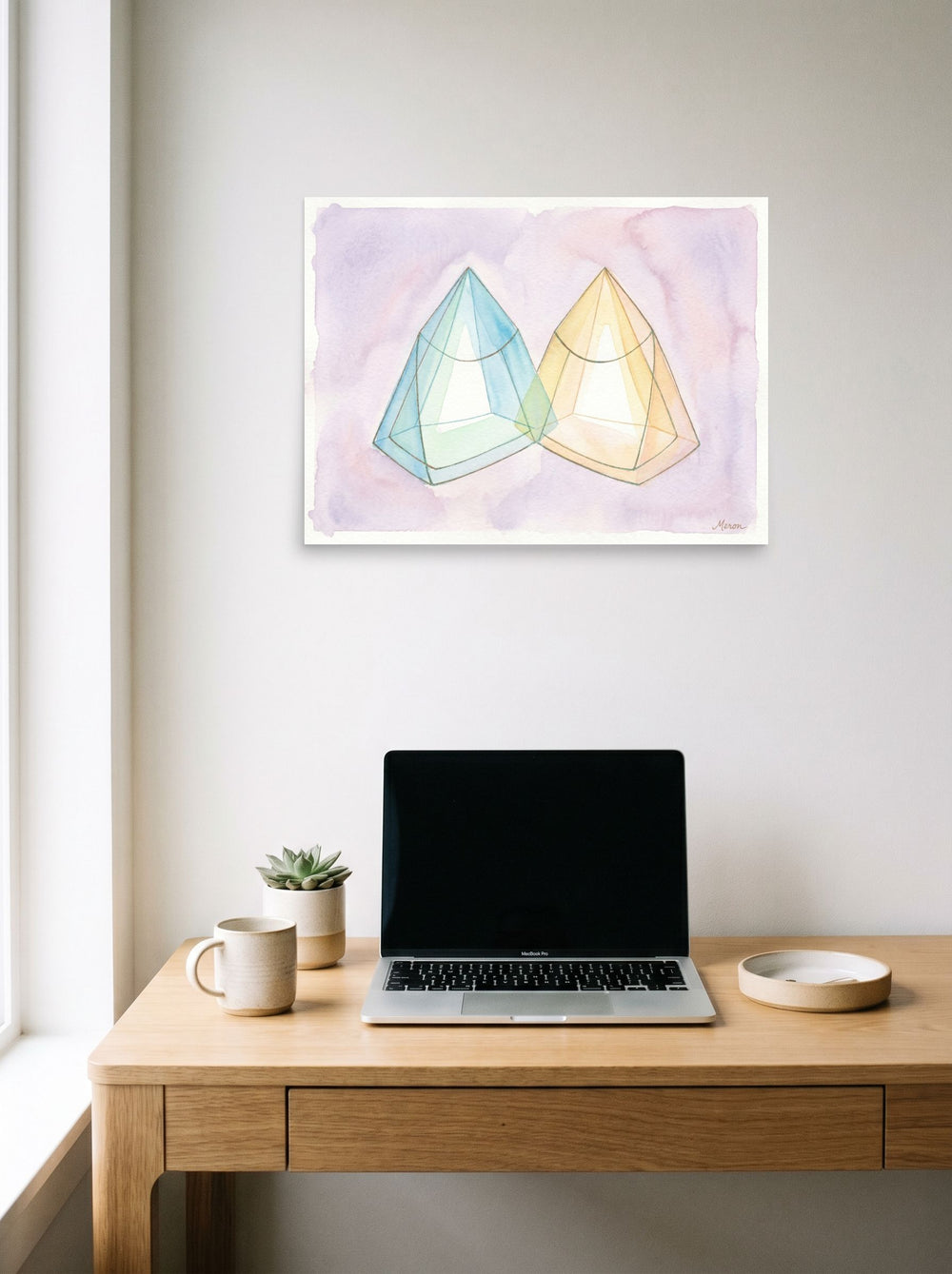 A 24x18 inch unframed paper Geometric abstract art print of 'Twin Babies Diptych' hanging above a worktable with a laptop.