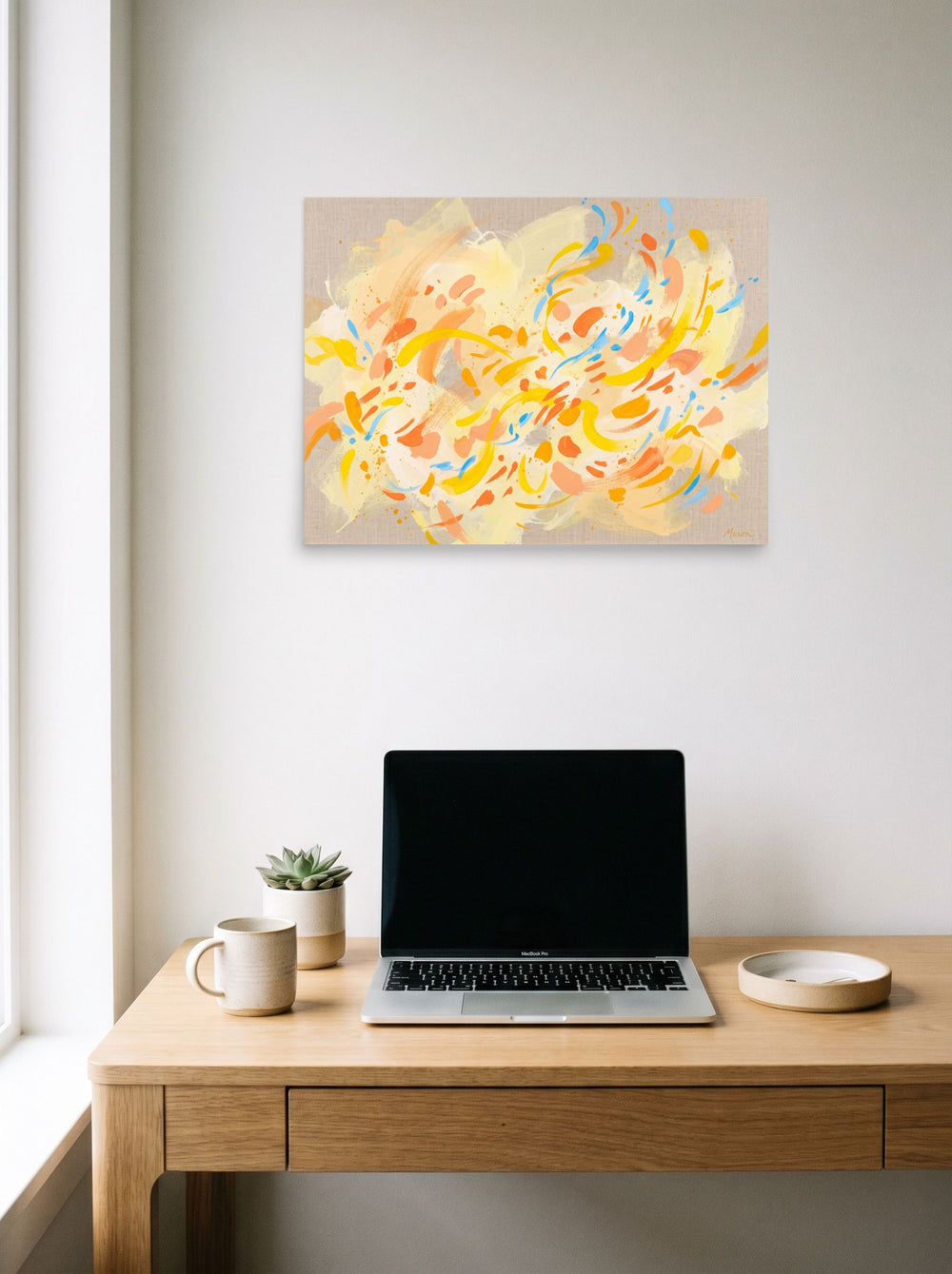 'Citrus Flutter' in 24x18 inch unframed paper, hanging above a worktable with a laptop.