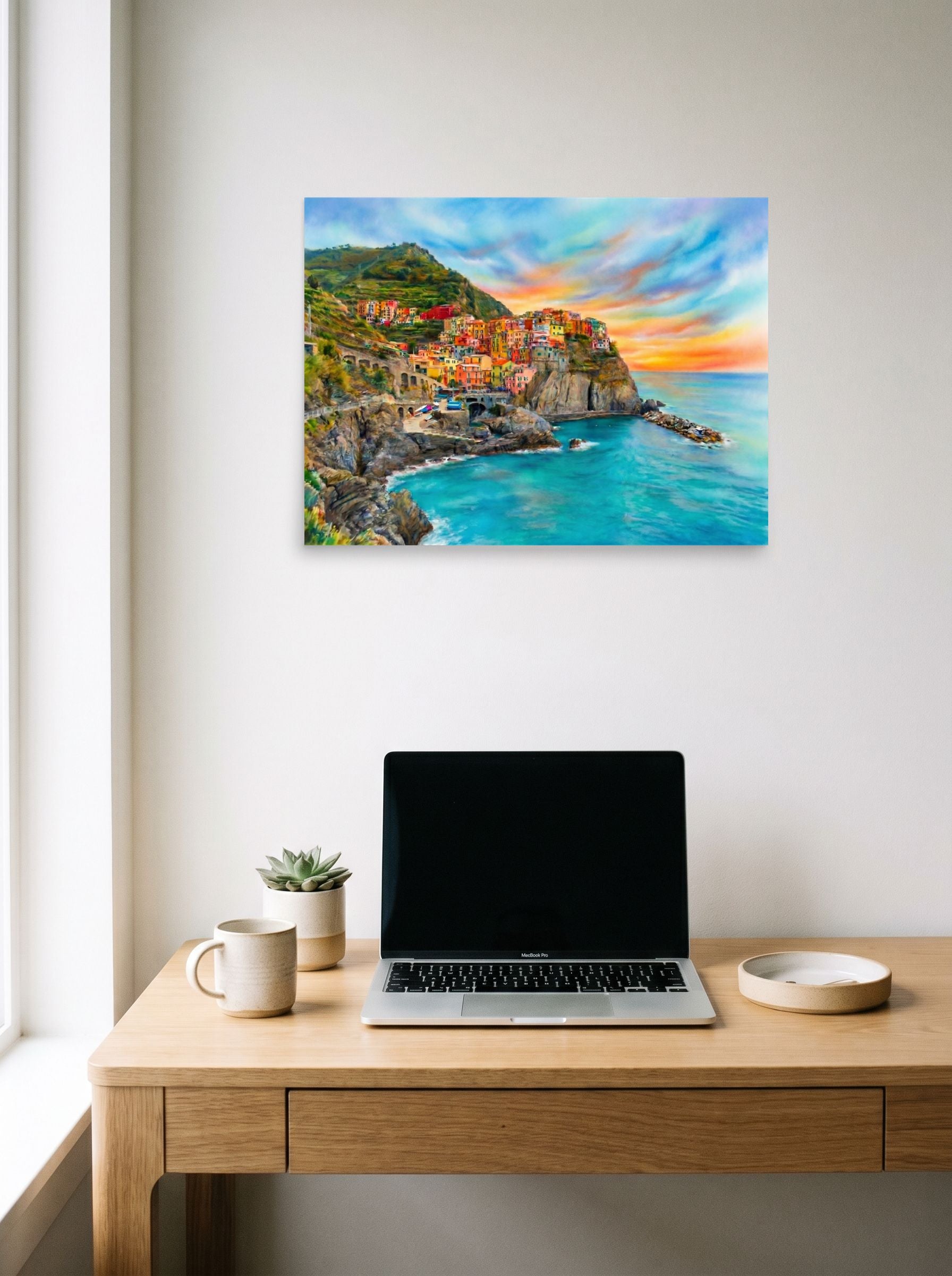 A 24x18 inch unframed paper Realism,Romanticism print of 'Coastal Dreams' hanging above a worktable with a laptop.