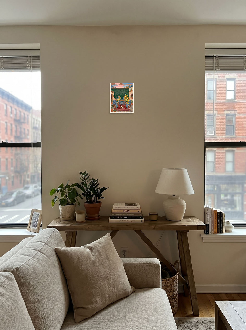 The Folk art print 'Courtyard Serenade', 8x10 inch unframed paper, anchoring a living room seating area.