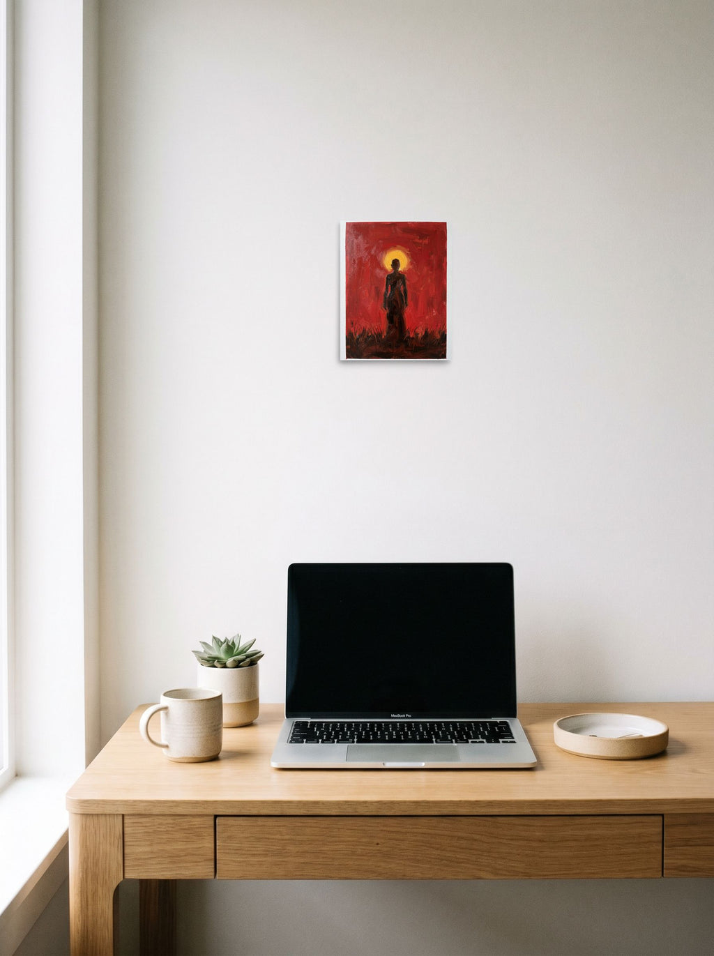 A 8x10 inch unframed paper Expressionism print of 'Crimson Halo' hanging above a worktable with a laptop.