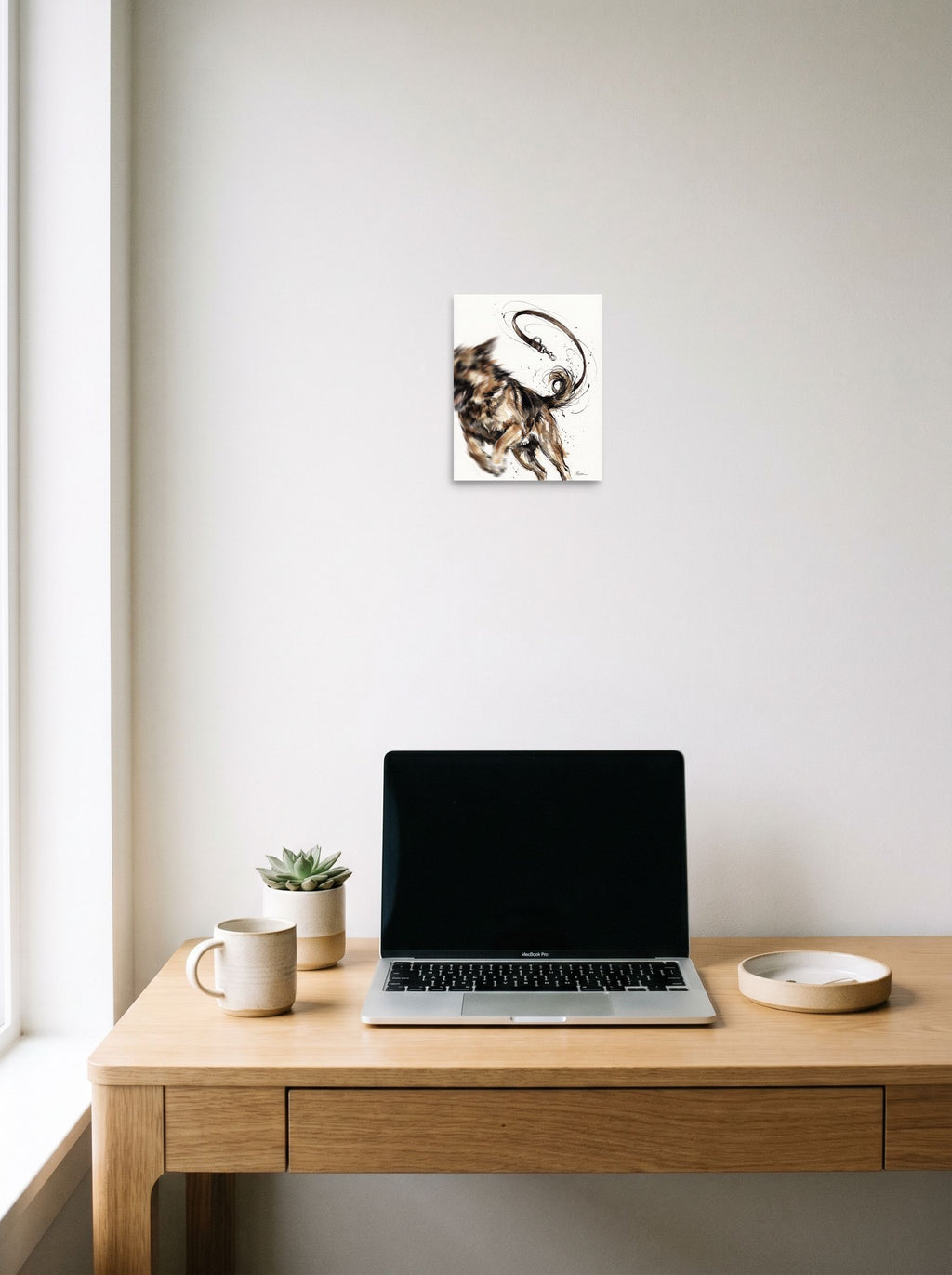 unframed paper wall art 'Unleashed Joy' hanging above a worktable with a laptop, at 8x10 inch.