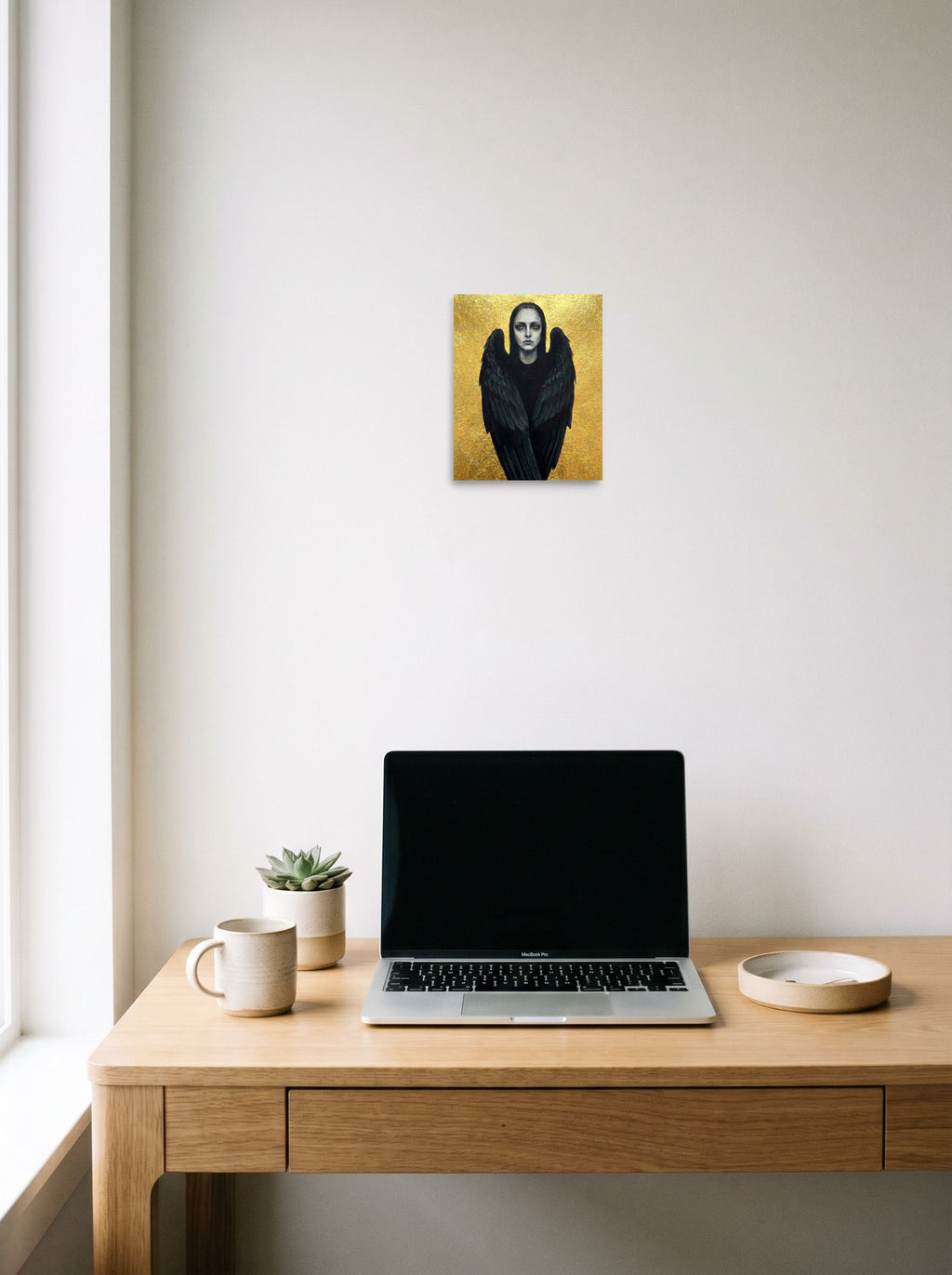 A 8x10 inch unframed paper Figurative art,Symbolism print of 'The Dark Seraph' hanging above a worktable with a laptop.