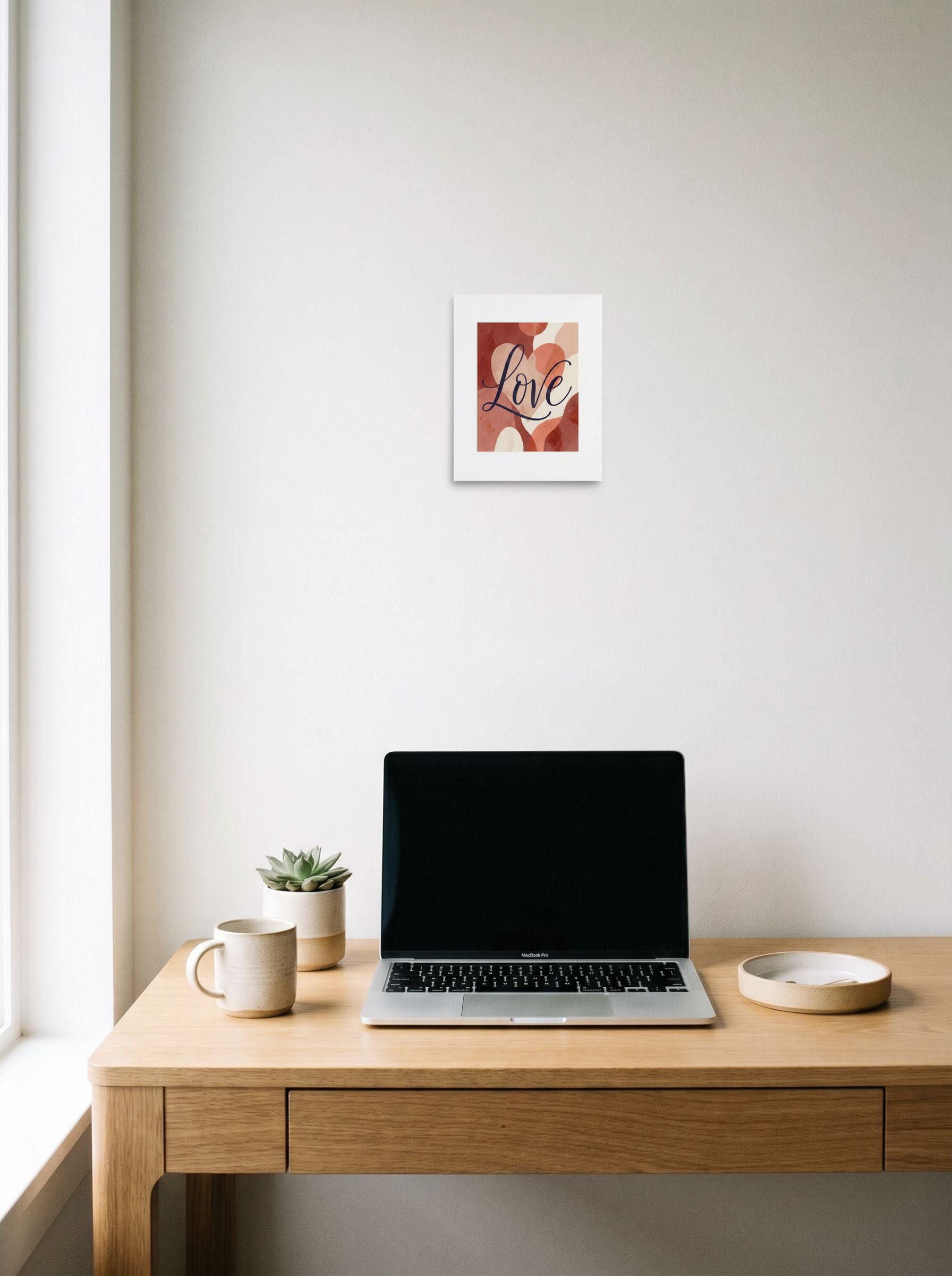 A 8x10 inch unframed paper Abstract art,Minimalism print of 'Painted Affection' hanging above a worktable with a laptop.