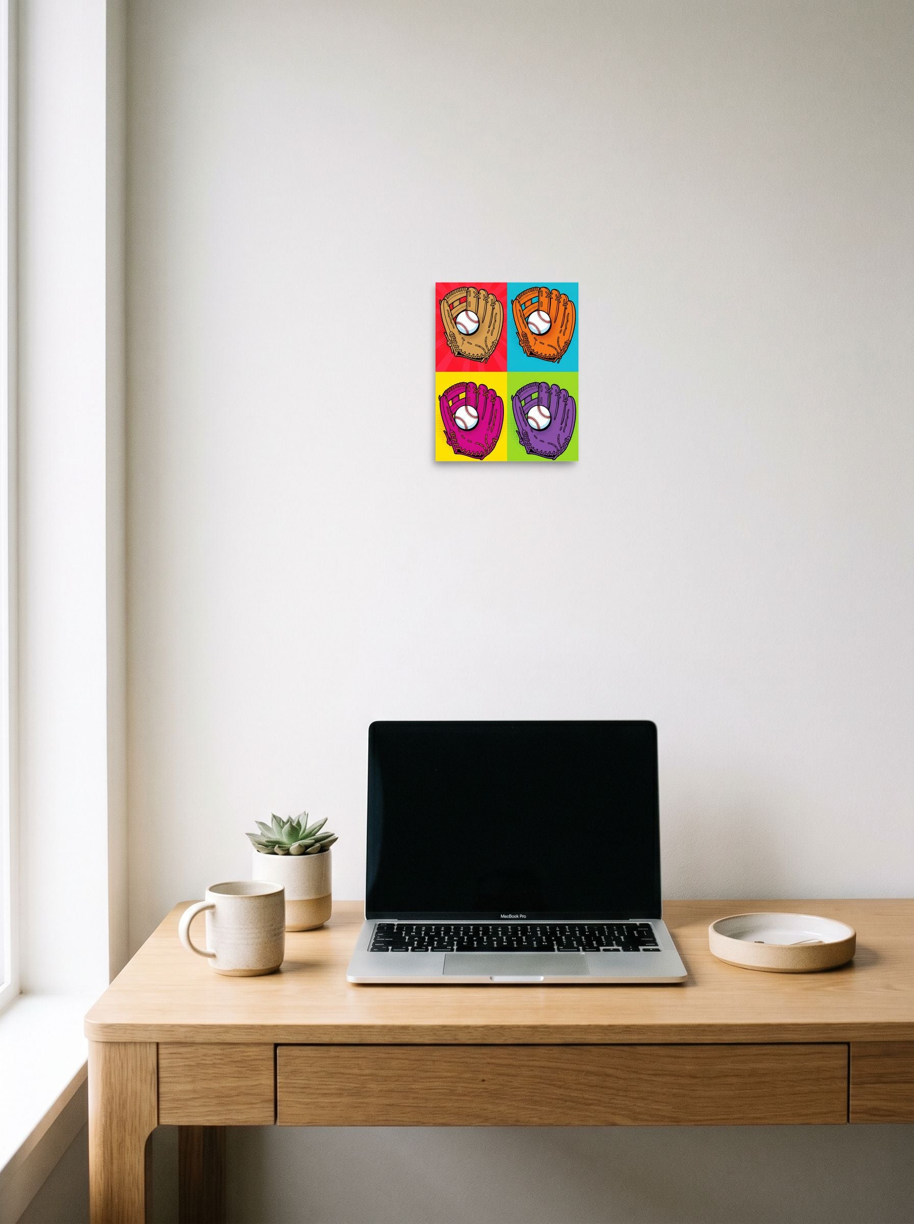 A 8x10 inch unframed paper Pop art print of 'Four Seam Pop' hanging above a worktable with a laptop.
