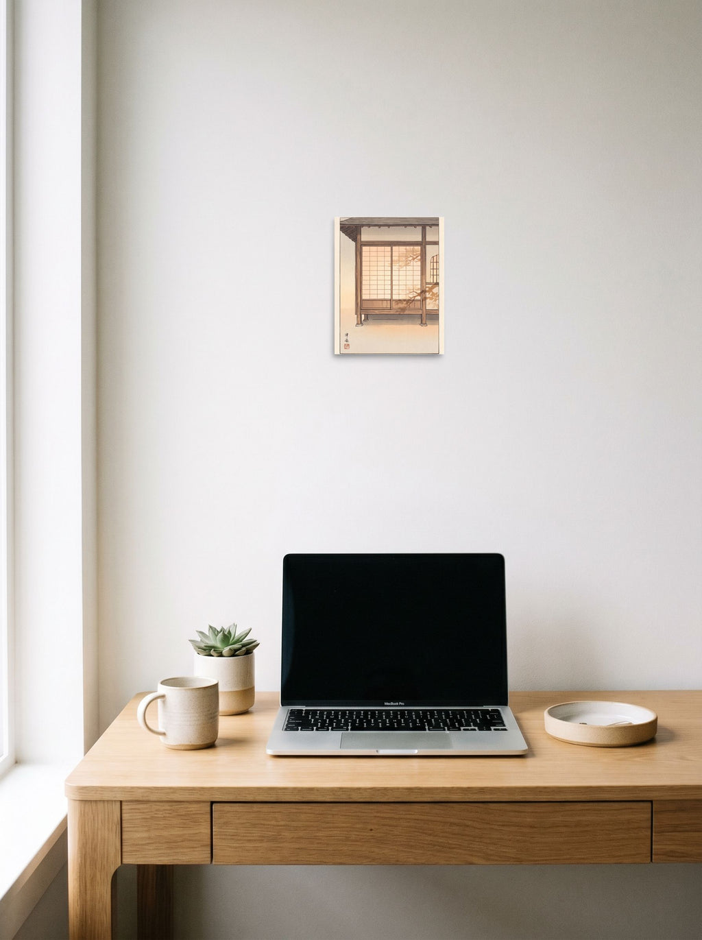 A 8x10 inch unframed paper Shin hanga print of 'Shadows on Shoji' hanging above a worktable with a laptop.