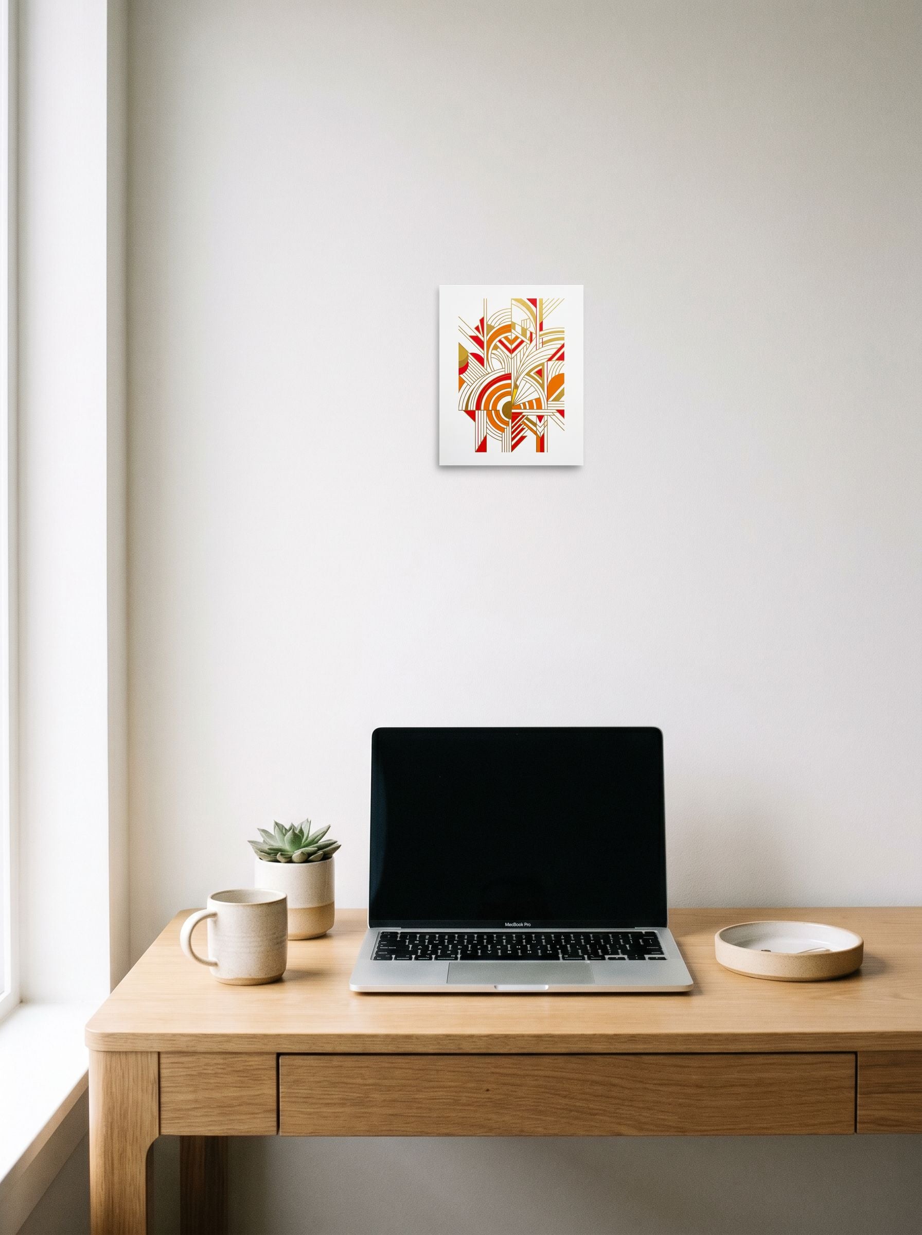 A 8x10 inch unframed paper Art Deco print of 'Radiant Deco Abstract' hanging above a worktable with a laptop.