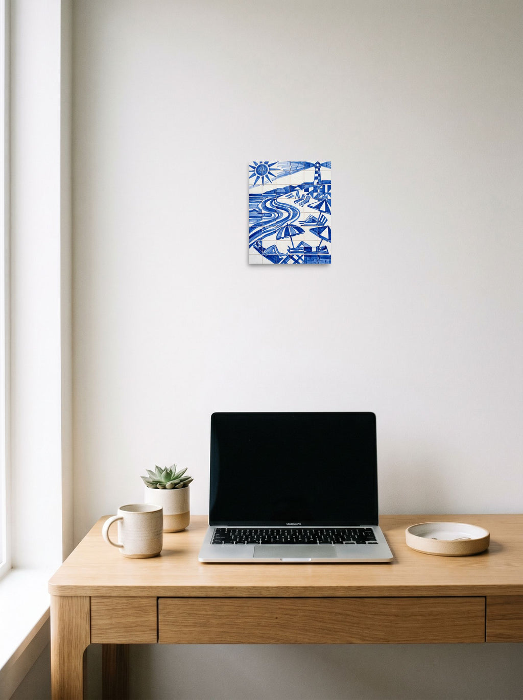 A 8x10 inch unframed paper Geometric abstract art print of 'The Blue Riviera' hanging above a worktable with a laptop.
