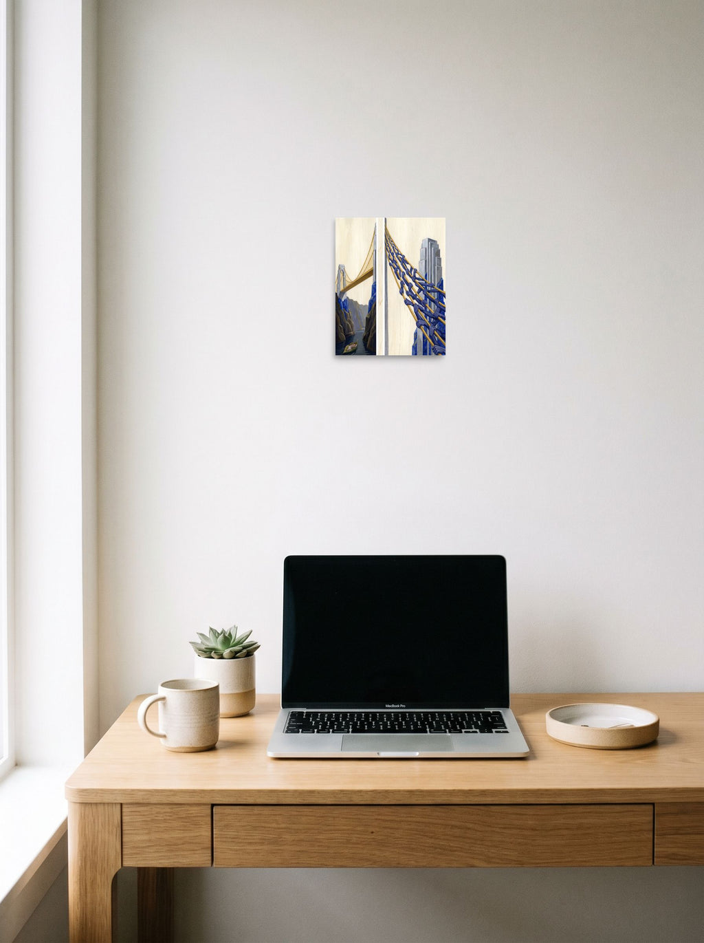 A 8x10 inch unframed paper Art Deco,Surrealism print of 'The Pillars of Dreams' hanging above a worktable with a laptop.