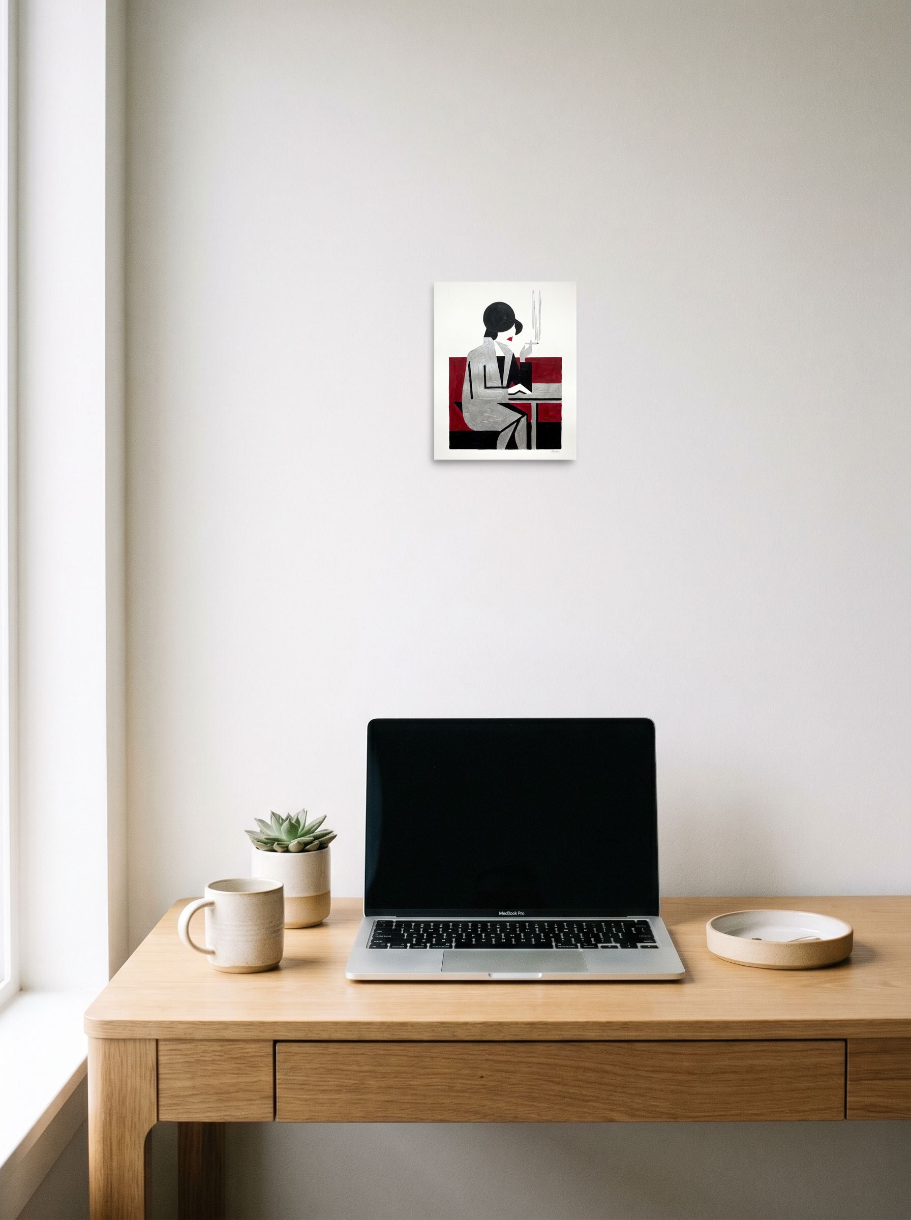 A 8x10 inch unframed paper Art Deco,Cubism print of 'Café Silhouette' hanging above a worktable with a laptop.
