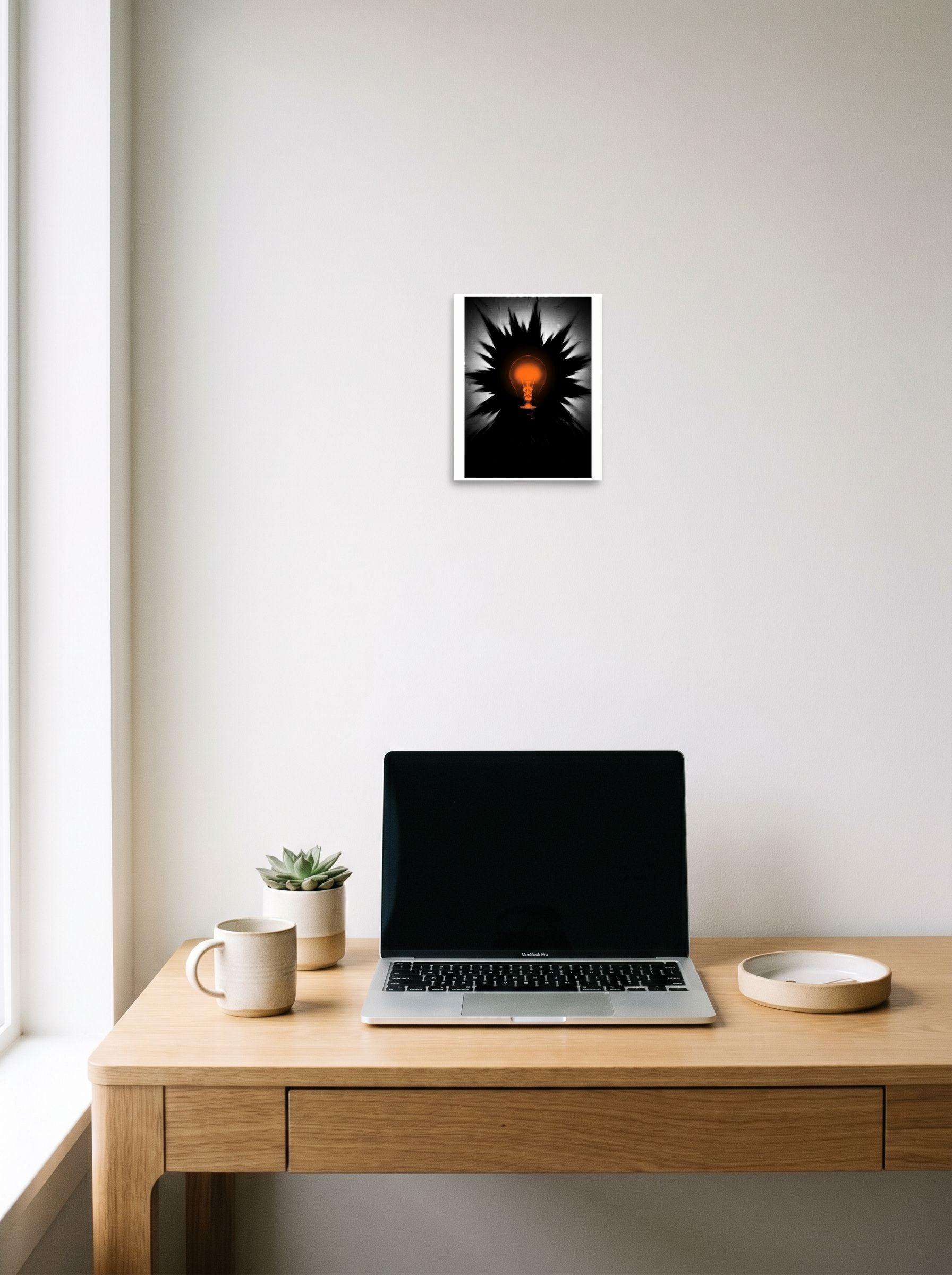 The unframed paper print 'Spark of Innovation' hanging above a worktable with a laptop, shown at 8x10 inch.