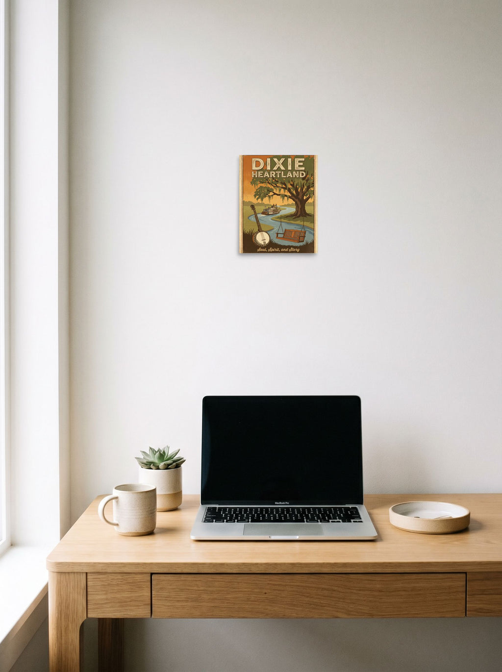A 8x10 inch unframed paper Regionalism print of 'Southern Soul' hanging above a worktable with a laptop.