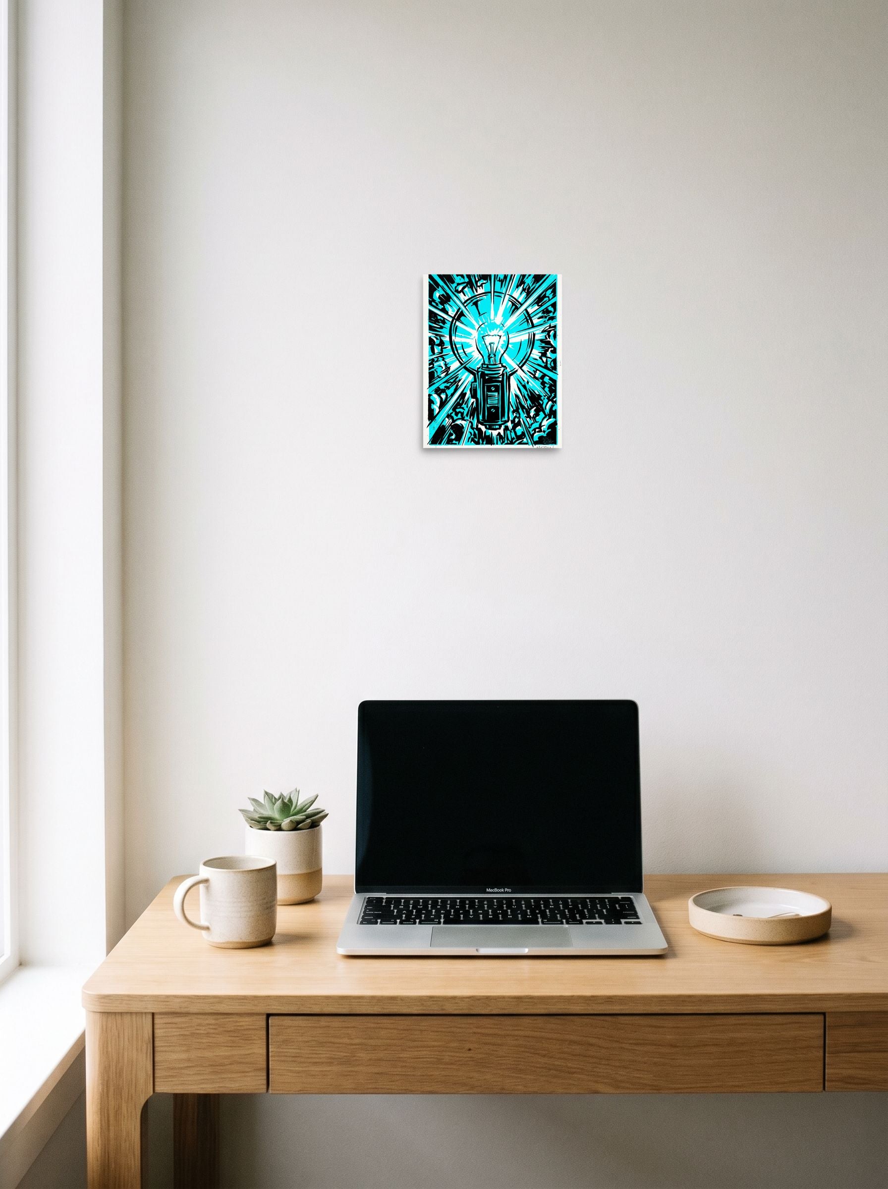 A 8x10 inch unframed paper Pop art print of 'Cyan Eureka' hanging above a worktable with a laptop.