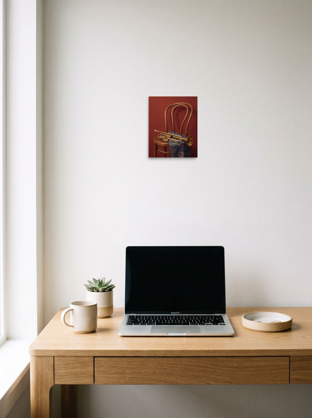 A 8x10 inch unframed paper Realism,Modernism print of 'Brass and Indigo' hanging above a worktable with a laptop.