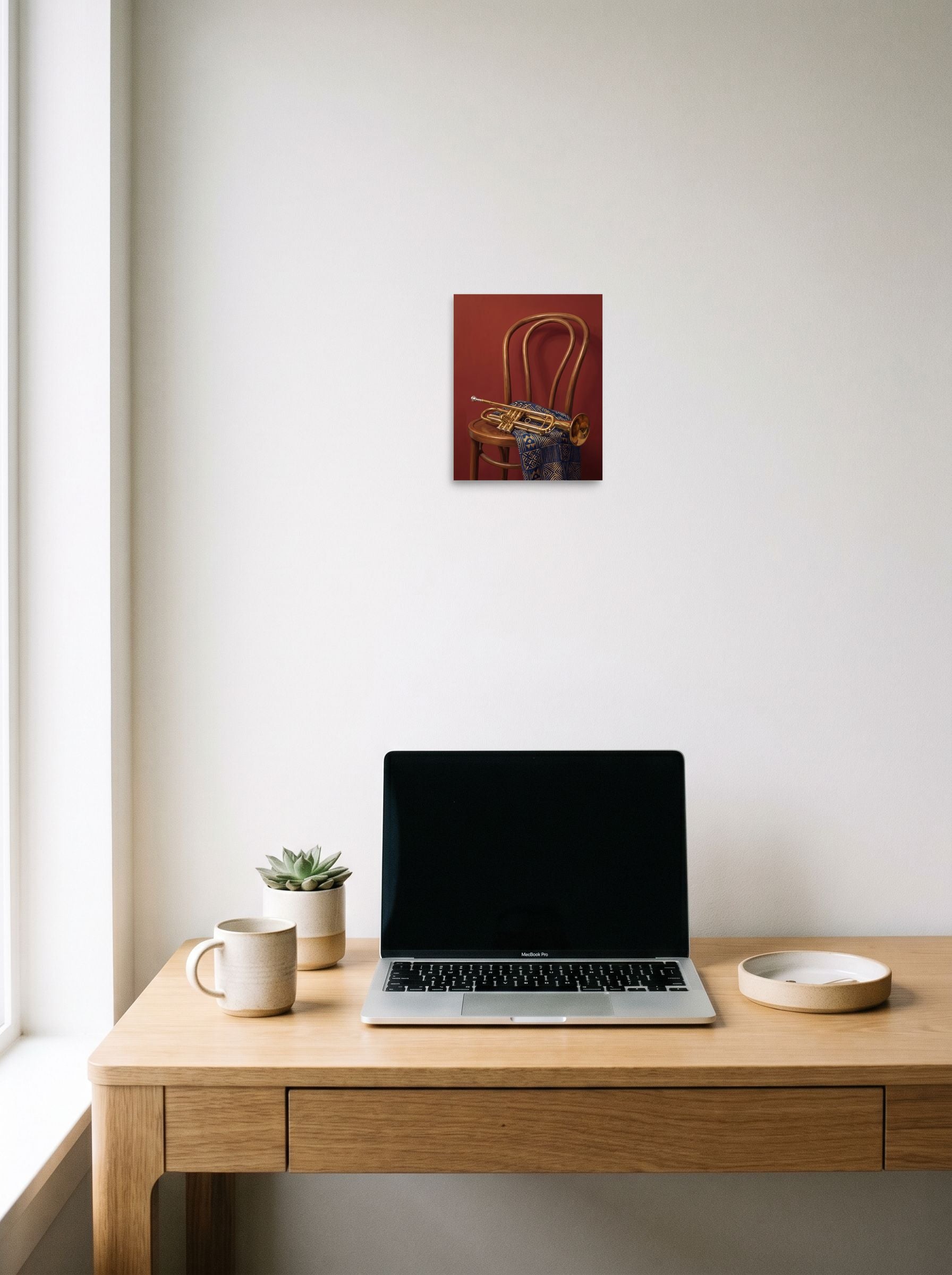 A 8x10 inch unframed paper Realism,Modernism print of 'Brass and Indigo' hanging above a worktable with a laptop.