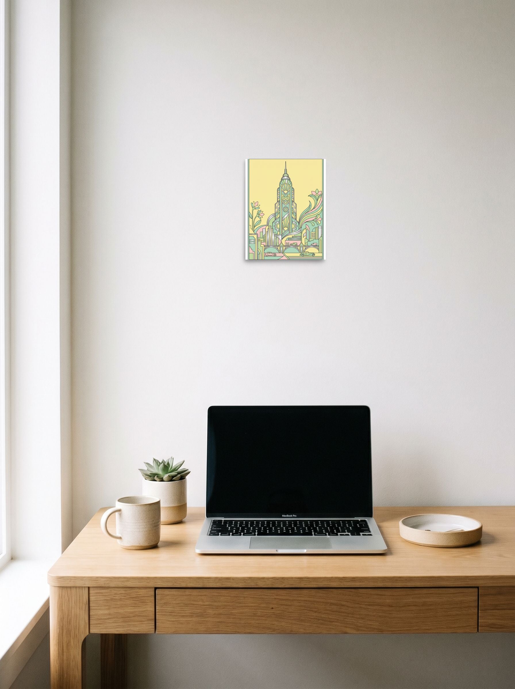 A 8x10 inch unframed paper Art Deco print of 'The Emerald Spire' hanging above a worktable with a laptop.