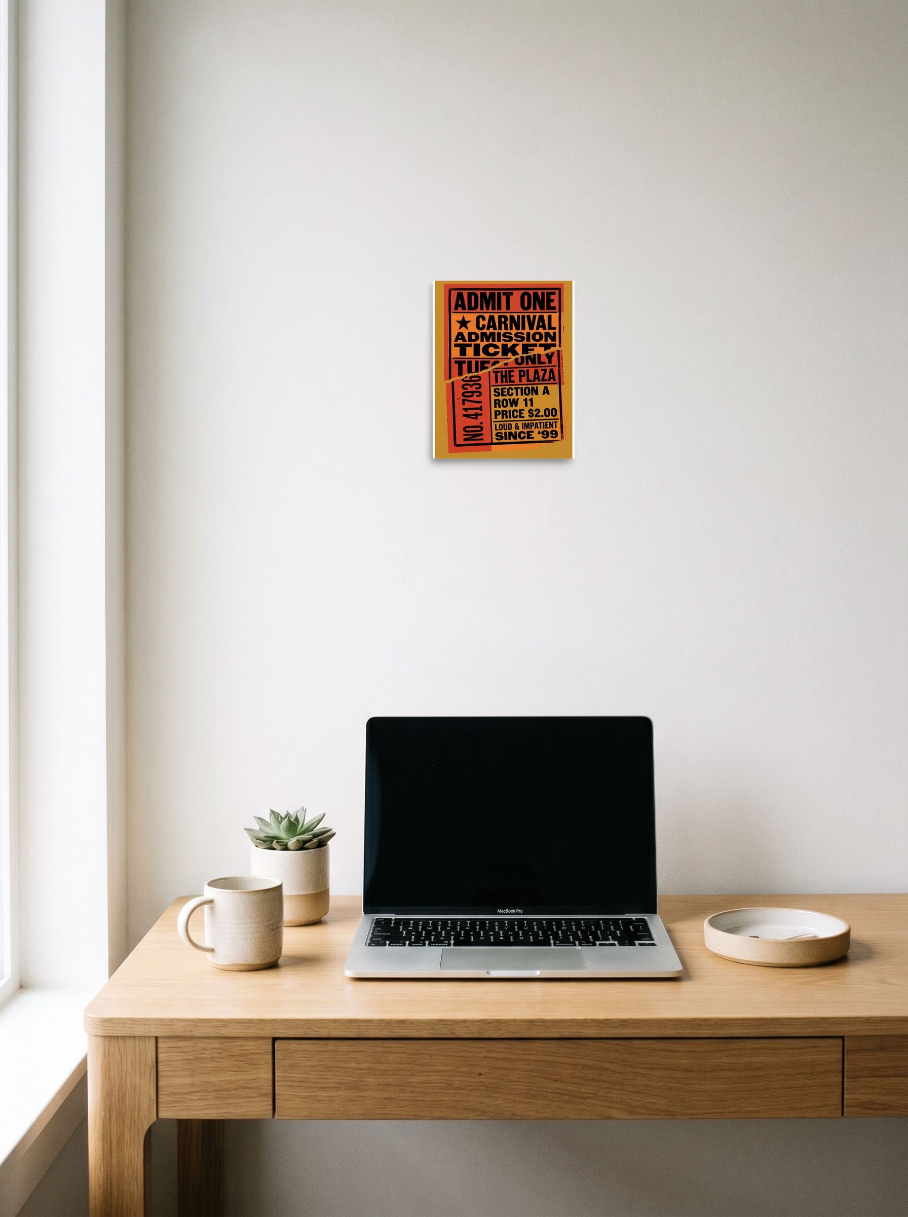 A 8x10 inch unframed paper Pop art print of 'Torn Admission' hanging above a worktable with a laptop.